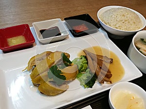 Asian Hainanese Chicken rice set, Thai gourmet steamed chicken with rice, soup, broccoli mushroom and seasoning chilli garlic sauc