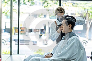 Asian hairdresser barber wear mask, cut hair of attractive man in shop. Handsome young man customer in modern salon barbershop,