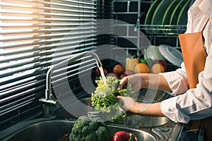Asian hands woman washing vegetables salad and preparation healthy food in kitchen