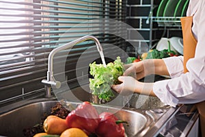 Asian hands woman washing vegetables salad and preparation healthy food in kitchen