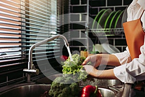 Asian hands woman washing vegetables salad and preparation healthy food in kitchen