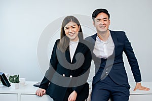 Asian handsome businessman and beautiful smart intelligent businesswoman wearing formal suits, working, smiling with success and