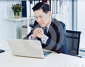 Asian handsome businessman in suit working with laptop computer on desk in office