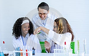 Asian handsome male teacher wearing eyeglasses and white gown uniform, teaching science and experiment to African black and