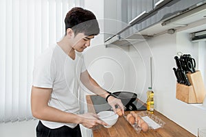 Asian Handsome man cooking in the kitchen at home