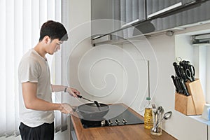 Asian Handsome man cooking in the kitchen at home