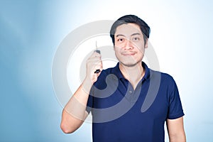 Asian handsome man with the keys of his new car, on blue backgro