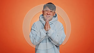 Asian handsome man praying, looking upward, making wish, begging apology, asking help, forgive me