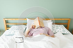 Asian handsome man Read books while sleeping. Man book cover Drowsiness causes sleep.The concept of adequate sleep. Good sleep