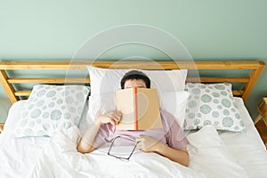 Asian handsome man Read books while sleeping. Man book cover Drowsiness causes sleep.The concept of adequate sleep. Good sleep