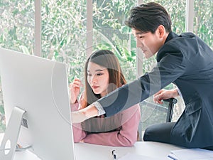 Asian handsome young businessman point to screen monitor