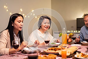 Asian happy big family enjoy spend time together celebrate holiday party, eat food and drink on dinner table at home. Loving