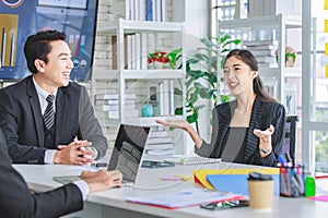 Asian happy cheerful professional successful female businesswoman employee in formal suit sitting smiling holding hands up