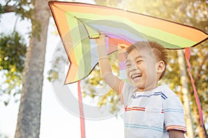 Asian happy children boy with a kite running to fly on in park