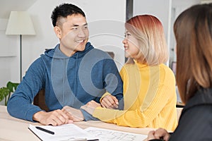 Asian happy couple buying new home with realtor agent with smiling face at new home.buying new house real estate.