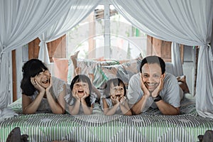 Asian happy family and child daughter relaxing on the bed