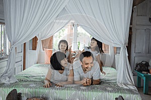 Asian happy family and child daughter relaxing on the bed