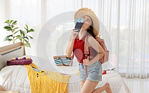 Asian happy female traveler with big hat and backpack smile and laugh with excited wow face holding passport and airplane travel