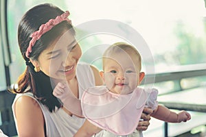 Asian happy mom holding happy baby girl. Vintage effects, soft f