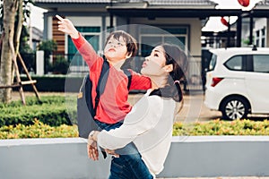 Asian happy mother carrying her kid, the kid point hand out