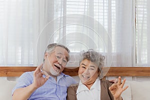 Asian happy retired senior smiling cute eldery couple enjoying & laughing together in home. Romantic relationship of lovely &