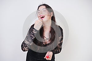 Asian happy woman paints her lips with lipstick on white studio background. Wrong try to do good self make up. Adult girl is learn