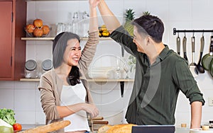 Asian happy young adult couple lover helping together for cooking in cozy home kitchen in morning, preparing meal for breakfast,
