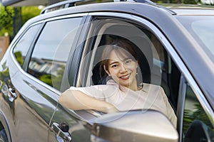 Asian happy young beautiful woman driving a car in front seat with smile prepare to journey with her car
