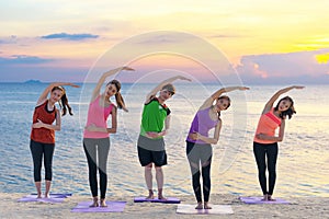 Asian healthy people lifestyle group exercising vital meditate and practicing yoga pose and training class on beach.