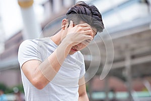 Asian healthy sport male headaches  expression from covid flu outdoor