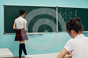 asian high school girl solves geometry on the blackboard