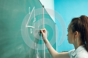 asian high school girl solves geometry on the blackboard