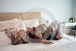 Asian hijab woman with friends cover face because of fear when watching horor film