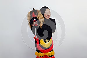 Asian hijab woman holding a Jatilan mask isolated on white background