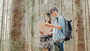 Asian hiker couple trekking in forest. Young happy backpack male and female walking enjoy her journey, travel nature and adventure