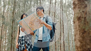 Asian hiker couple trekking in forest. Young happy backpack male and female walking enjoy her journey, travel nature and adventure