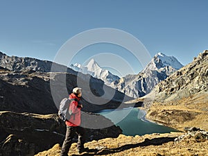 Asian hiker looking at mount jampayang and chanadorje and lake boyongcuo in yading, daocheng