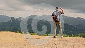 asian hiker man with backpack happy feeling stand and see to mountain view