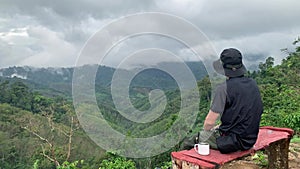 asian hiker man relax and happy feeling drink coffee and see to mountain view