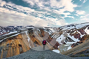 Asian hiker woman standing on top of volcanic mountain named Blanhjukur trail in summer at Landmannalaugar