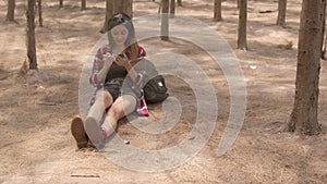 Asian hiker woman trekking in forest. Young happy backpack girl using mobile phone direction map while travel nature and adventure