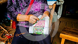 Asian hill tribe woman embroidering traditional handicraft