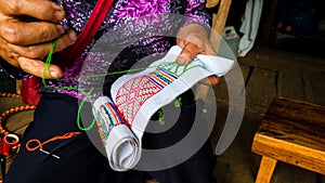 Asian hill tribe woman embroidering traditional handicraft photo