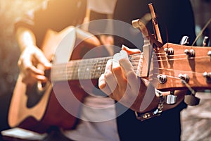 Asian hipster man left hand catch chord and playing music.