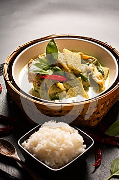 Asian home cooking Concept Thai chicken and baby bamboo Green curry and rice on black background with copy space