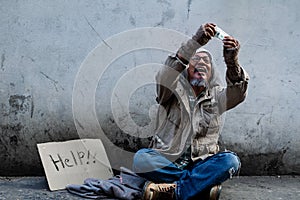 Asijský bez domova muž po přijímání bankovky na pomoc. muž dlouho vlasy nepořádný vousy sedět a jíst starý stěny 