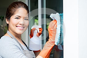 Asian housewife cleaning on window glass
