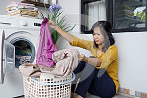 asian housewife doing some laundry at home feeling angry