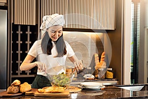 Asian housewife preparing fresh vegetables to make salad at home kitchen counter