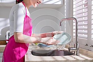 Asian housewife wash dishes